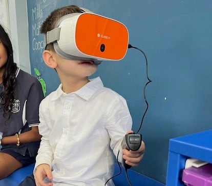 Image of a young student wearing a virtual reality headset and remote control