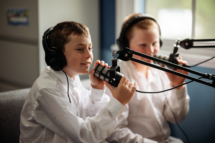 Photo of a student speaking in to a podcast microphone