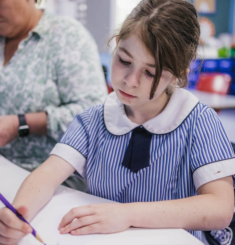 Photo of a student seated at a desk, writing